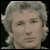 Static pixelated image of a person's face with gray hair and neutral expression on dark background.