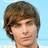 A pixelated image of a person with brown hair against a light blue background, with pink text reading "Shelby LOVES ZAC EFRON!" on a cyan and gray split background.