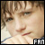 Pixelated close-up of a person's face with light brown hair, visible eye and mouth details, and 'FAN' text in the bottom-right corner.