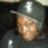 A person wearing a dark cap with a white emblem and dark clothing, shown in four where the head shifts slightly left to right