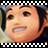 Pixelated close-up of a person's face with light skin tone, dark brown eyes, and dark hair, framed by a black-and-white checkered border.