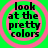 Four identical circular icons with pink concentric rings on a bright green background, each containing black text reading 'look at the pretty colors' in a pixelated font.