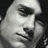 Pixelated grayscale close-up of a person's face showing eyes, nose, and mouth with visible pixelation on dark background.