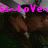 Pixelated image with bright pink text "SsnLover" overlaid on a dark, indistinct background featuring brown and green tones.