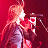 Animated contact sheet showing two frames of a cartoon character with long orange hair singing into a microphone against a red background.