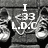 Pixelated grayscale image showing a character with a large head and wide eyes, wearing a dark outfit with light accents, holding a small object near the face.