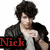 Pixelated image of a person with dark curly hair wearing a black jacket over a white shirt, red lips, and a red mark on the right wrist, with 'Nick' text in red letters at bottom left.