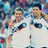 A pixelated image of a person in a white sports jersey with dark and red accents, standing in front of a blurred crowd background.
