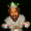 Animated figure in royal attire with crown and fur-trimmed robe, holding a small object, with green text overlays changing across frames.