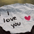 A crumpled white paper with 'I love you' text and a red heart symbol, displayed in a with visible pixelation