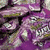 Pixelated image with green background sections and purple text reading "makes me want to lick the wrapper!" alongside a textured purple object.