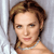 Pixelated portrait of a person with light brown hair styled in an updo, wearing a white strapless garment against a light gray background.