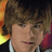 Pixelated image of a person with light brown hair and blue eyes, wearing dark clothing against an orange background with pink star symbols.