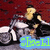 A person in a black sleeveless top rides a silver motorcycle against a red background with blue text overlay.