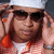 A person wearing a white cap, dark sunglasses, and an orange-and-white striped shirt adjusts their cap with both hands, with text overlays reading 'C.G.' and 'T-DUBB' in the lower corners.