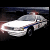 Four of a white police car with blue stripes and red emergency lights, shown from front-three-quarter view against dark background