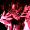 Animated sequence showing a figure with long hair and hands raised against dark background, transitioning from blurred motion to clearer hand gestures.