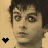 Static 48x48 pixel buddy icon featuring a close-up of a person's face with dark hair against a light beige background, accompanied by a small black heart symbol in the bottom-left corner.