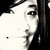 Black-and-white pixelated image of a person's face with visible eyes, nose, mouth, and hair in four -like sections