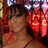 Pixelated static image of a person with dark hair and red clothing against a blurred background.