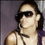 Pixelated image of a person with dark hair wearing sunglasses and a sleeveless top against a muted purple background.
