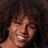 Pixelated close-up of a person's face with light skin tone, dark hair, and closed eyes against a dark background.