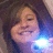 A person with brown hair and a blue light effect near their shoulder in a of four
