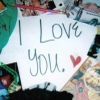 A static image shows handwritten text "I Love You." with a red heart symbol on a white background, surrounded by blurred colorful elements.