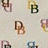 Animated pattern of repeating 'DB' monograms and text fragments on a light background with visible pixelation.