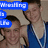 Two young men in blue wrestling singlets pose together with text overlays reading "Wrestling is Life" in blue boxes.