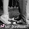 Black-and-white image of two people's lower legs and feet wearing sneakers, with pink heart symbols and text at the bottom.