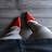 Pixelated static icon showing two red and white shapes against a gray background with visible dithering and compression artifacts.