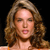 A pixelated close-up of a person with long wavy brown hair, closed eyes, and a slightly open mouth against a black background.