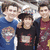Four pixelated figures in a group pose, three standing behind one central figure with arms raised.