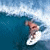 Pixelated image of a person surfing on a wave with blue water and white foam, viewed from above.