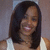 A static pixelated image of a person with long dark hair wearing a light-colored sleeveless top against a muted background.