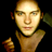 Pixelated static image of a person's face and upper torso with warm lighting against black background, rendered in low-resolution 256x256 pixels.