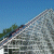 Pixelated landscape showing a sloped structure with blue sky and green foliage in the background.