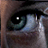 A close-up of a single human eye with visible eyelashes, iris details, and a reflection in the pupil against a dark background.