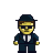 Pixel art character with yellow face, dark blue suit, white shirt, black tie, and dark blue fedora, standing against solid gray background.