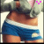 A pixelated image of a person wearing blue shorts with white trim and a gray top, showing the lower torso from waist to upper thighs.