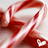 A pixelated red and white abstract shape with curved lines forming a dynamic, swirling pattern against a light gray background.