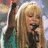 A pixelated image shows a person with long blonde hair holding a microphone on the left, next to bright pink background with blue text reading "chill it out take it slow thn u roc out the show".