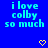 Blue background with cyan text reading "i love colby so much" repeated across the image, accompanied by yellow pixelated heart and arrow symbols.