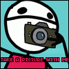 Pixelated character with white helmet and black dots holds brown camera against cyan background, red text below reads "TAKE A PICTURE WITH ME".