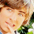 Pixelated close-up of a person with light brown hair, fair skin, and visible facial features including eyes, nose, and mouth, set against a blurred background.