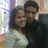Two people in close embrace, one wearing dark clothing and the other light-colored top with visible shoulder strap.