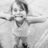Black-and-white photo of a child with arms raised, surrounded by pink pixelated text reading "Lil Kids Are Funnier When They Aren't Pretending To Be :o)".