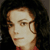 Static pixelated image of a person with dark hair and light skin wearing red clothing against a black background.