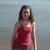 A pixelated static image shows a person in a sleeveless red top standing against a blurred background with light blue and gray tones.